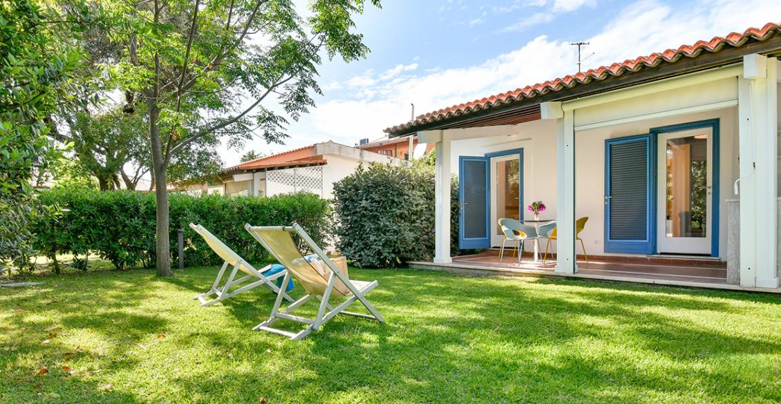 Giardino verdeggiante, casa accogliente con tetto rosso, atmosfera tranquilla e serena.