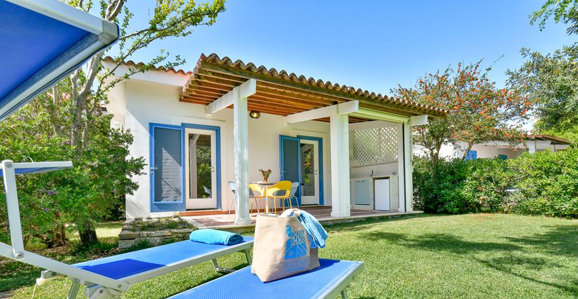 Giardino soleggiato con sdraio blu e veranda accogliente.