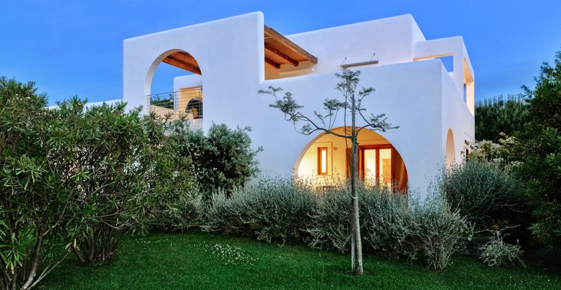 Giardino sereno con alberi e casa bianca, atmosfera di pace e tranquillità.