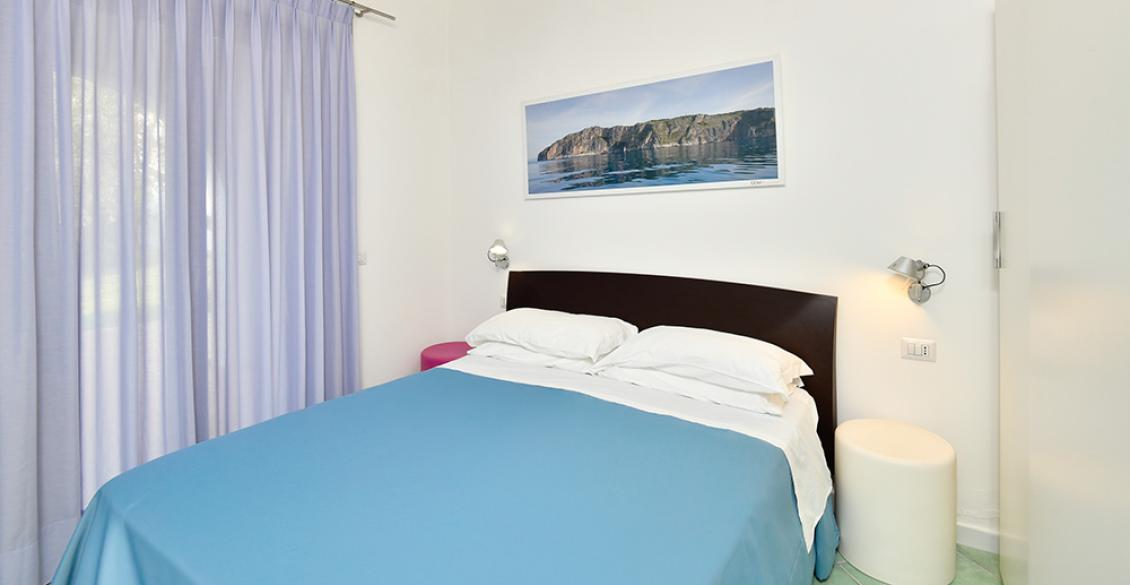 Camera semplice e luminosa, letto matrimoniale, atmosfera rilassante con arte murale.