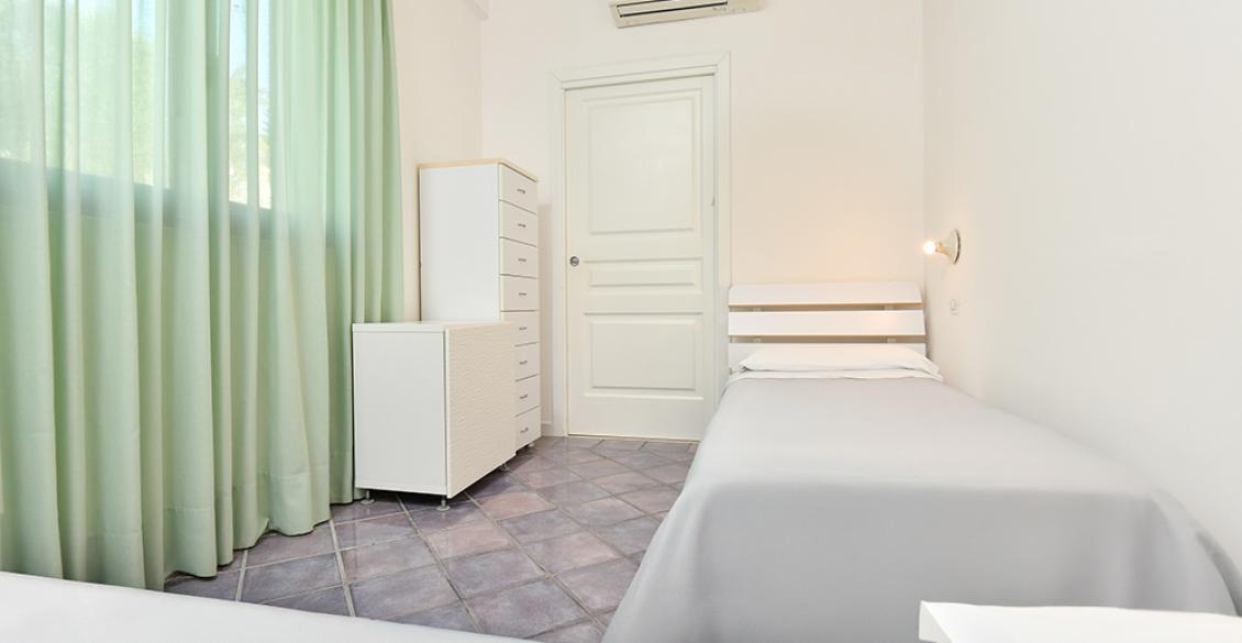 Cucina vivace con mobili rossi, sedie colorate e atmosfera allegra e accogliente.