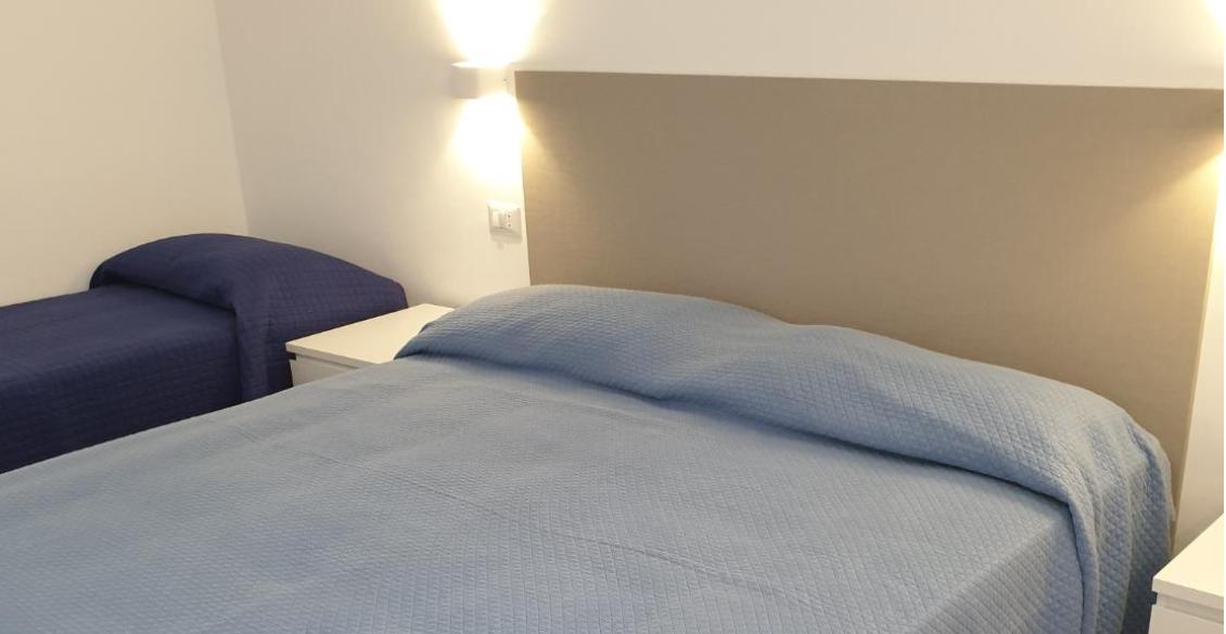 Camera accogliente con letti ordinati, atmosfera rilassante e luce soffusa.