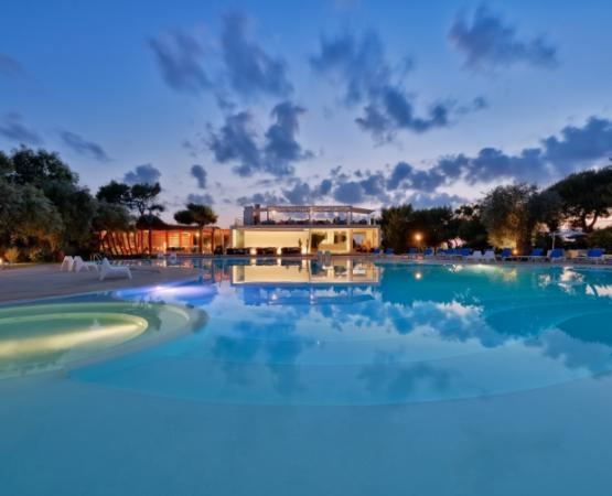 Piscina illuminata al tramonto, atmosfera serena e rilassante con cielo nuvoloso incantevole.