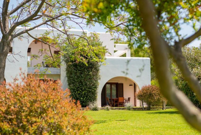 Villa bianca immersa nel verde, atmosfera serena e accogliente, perfetta per rilassarsi.