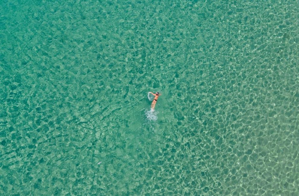 Persona nuota in mare cristallino, trasmette libertà e serenità infinita.